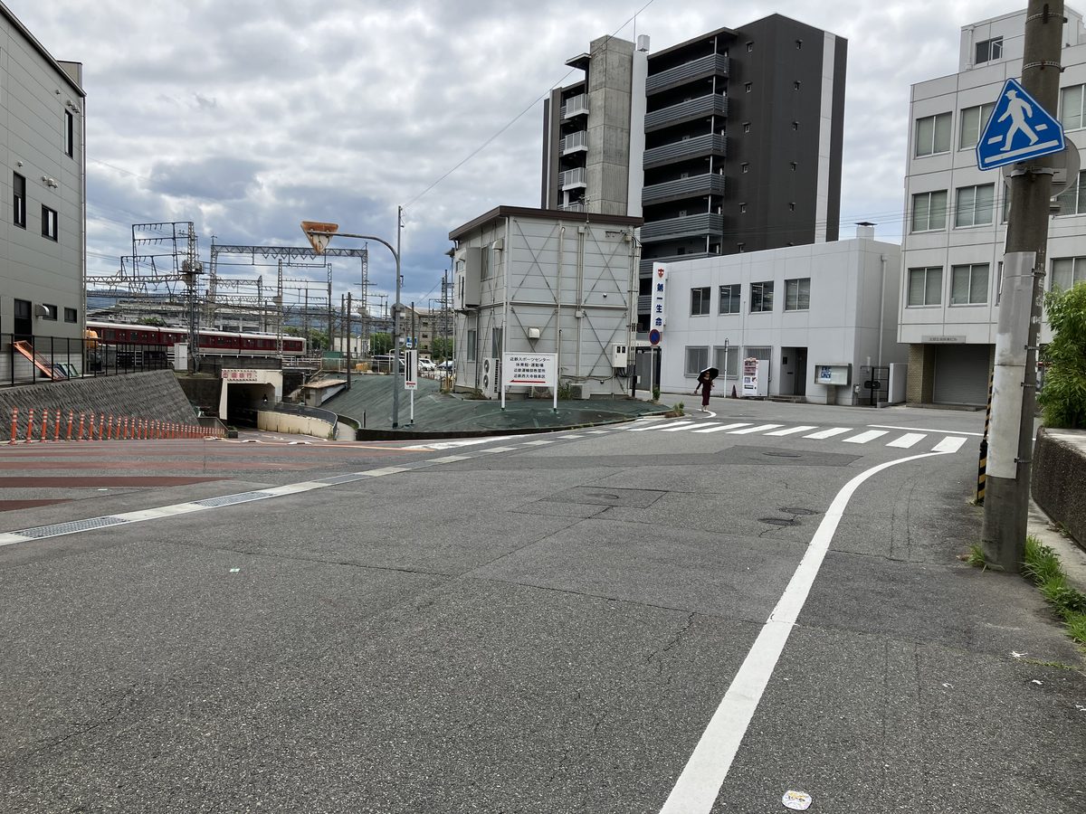 The underpass of the Kintetsu Nara Line ahead to the left, and a pedestrian crossing ahead to the right
